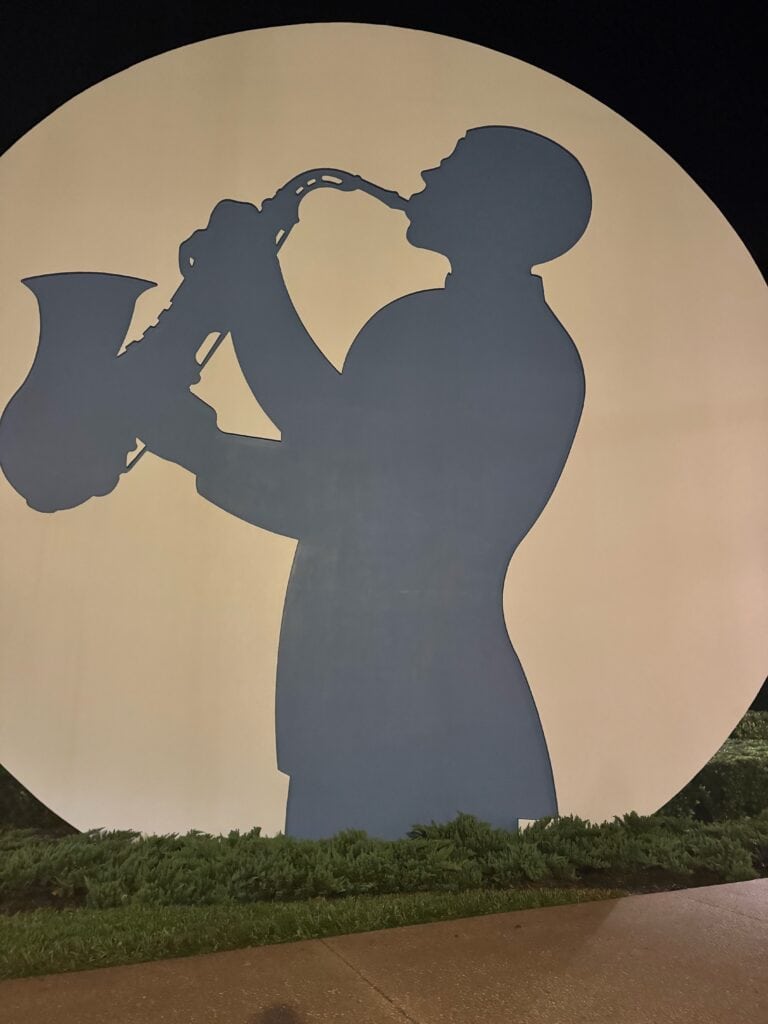 Large silhouette of a saxophone player painted on a circular backdrop at Disney’s All Star Music Resort, part of the resort’s oversized music-themed décor.