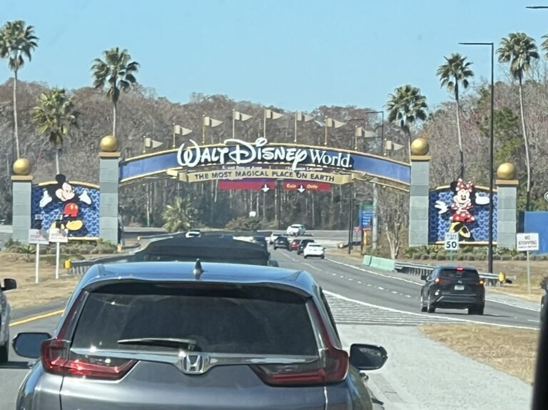 Arriving at the Walt Disney World welcome sign after traveling from Orlando International Airport to Disney World.