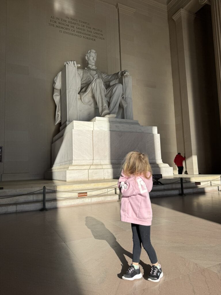 Child looking up at the Lincoln Memorial statue in Washington DC with kids