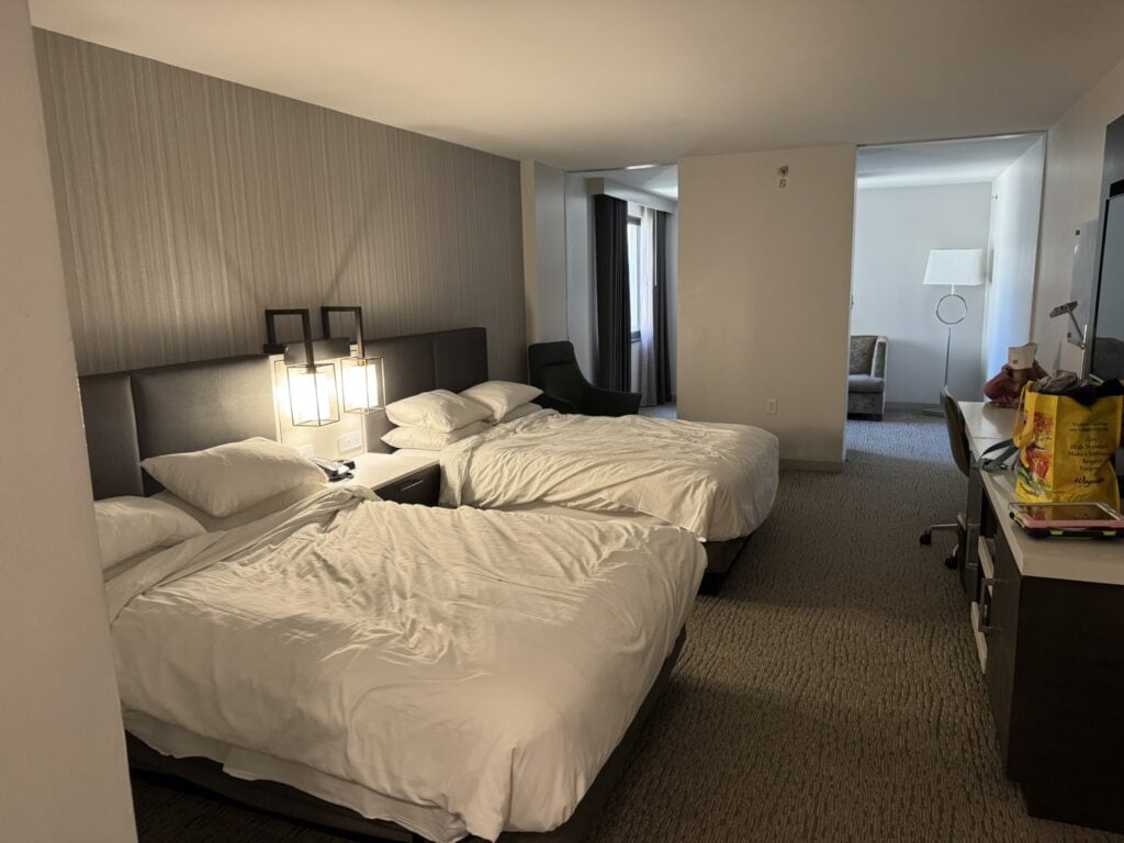 Two double beds in a Washington Marriott Georgetown guest room with seating area and workspace