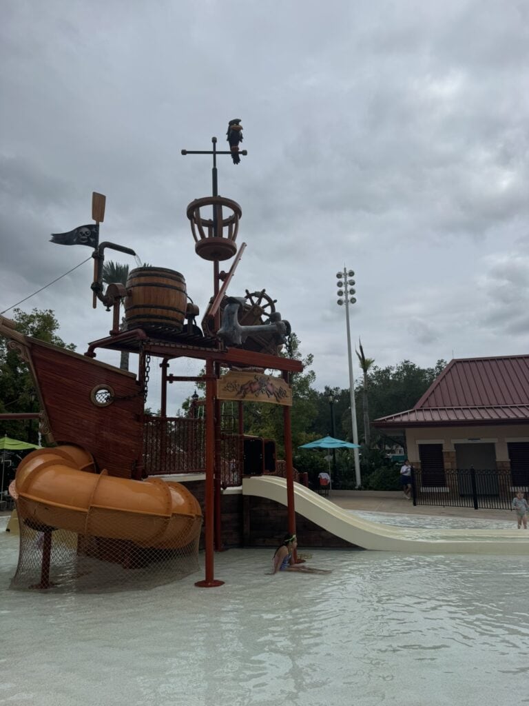 Pirate ship-themed splash area at Disney's Caribbean Beach Resort with shallow water, small slides, and interactive water features for younger kids.