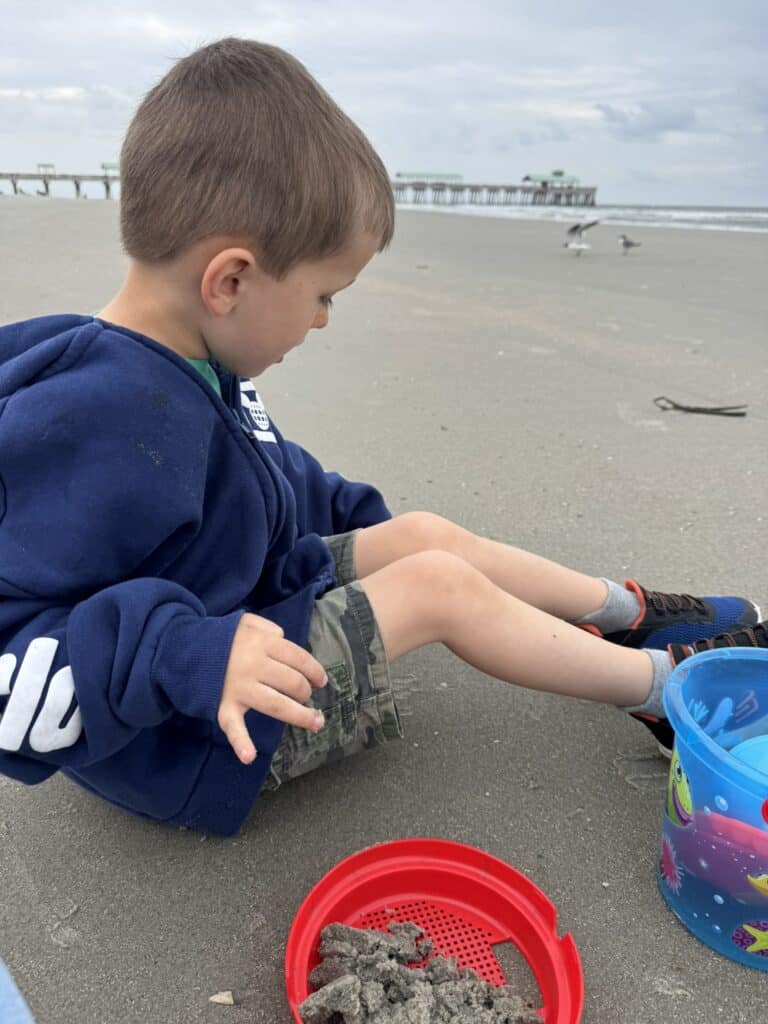 Child playing in the sand at Folly Beach during a Charleston SC with kids itinerary.