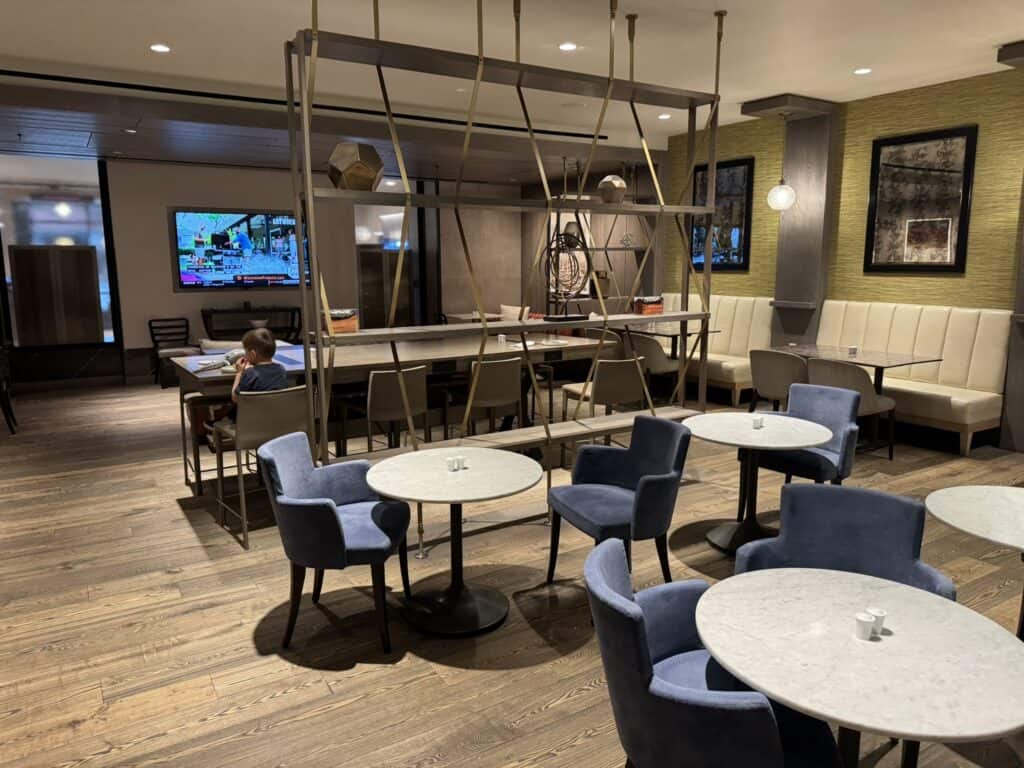 M Club lounge at Charlotte Marriott City Center with kids, including tables, chairs, and a seating area.
