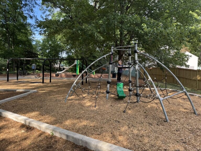 Child climbing on the playground at Fourth Ward Park during a Charlotte NC with kids trip.