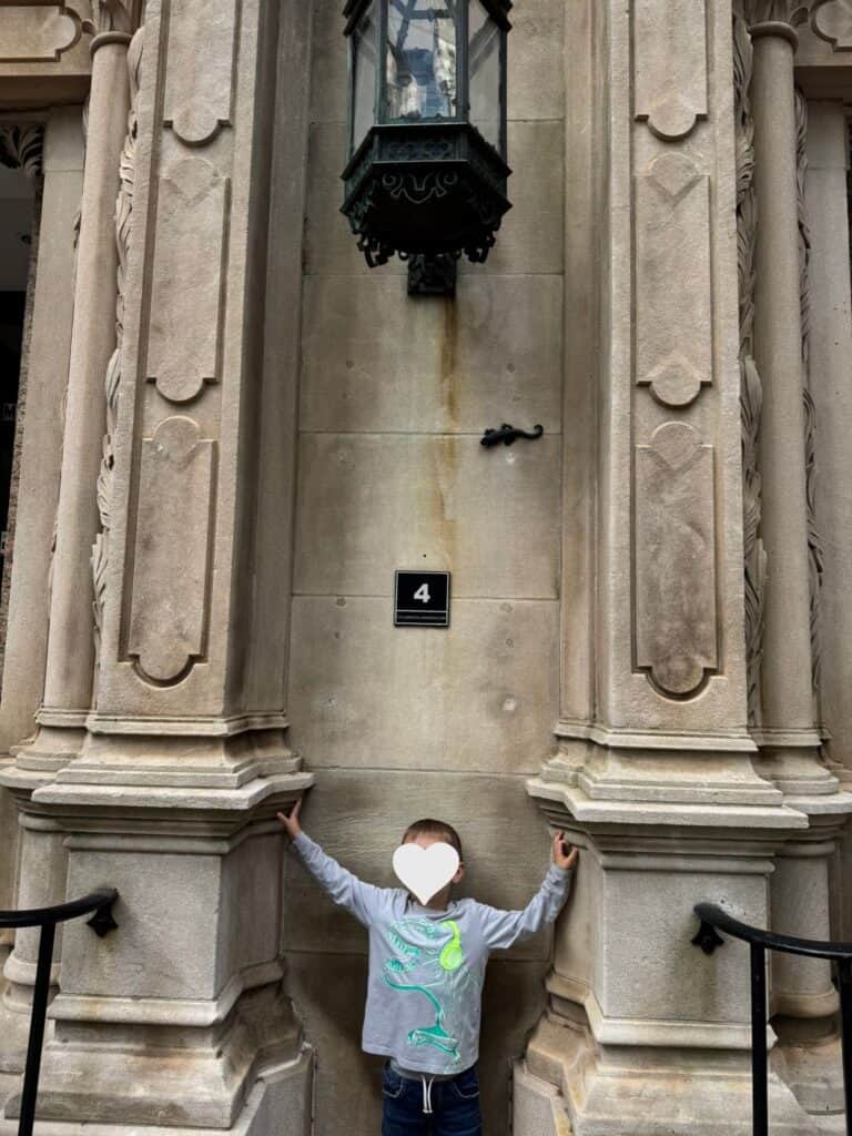 Child standing below a Sally Salamander walking tour marker in downtown Columbia.