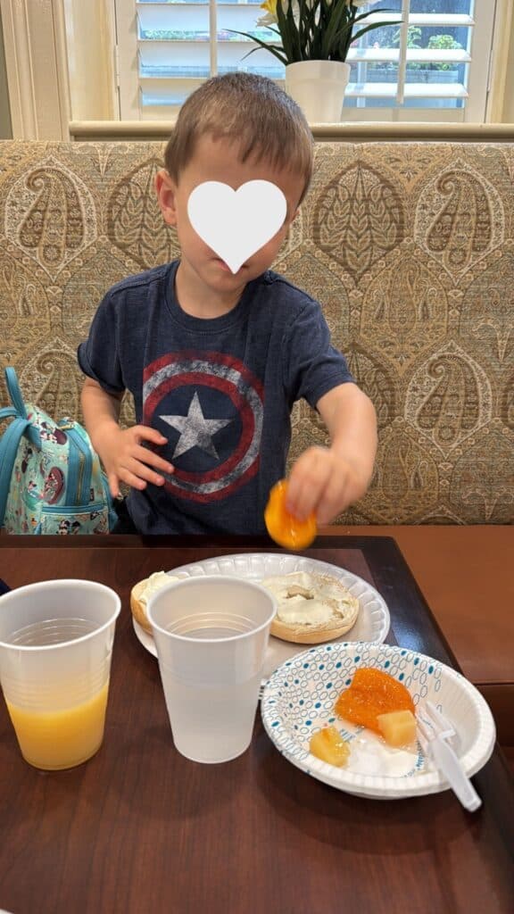 Child eating a bagel and fruit during the free breakfast at Hampton Inn Charleston-Historic District.
