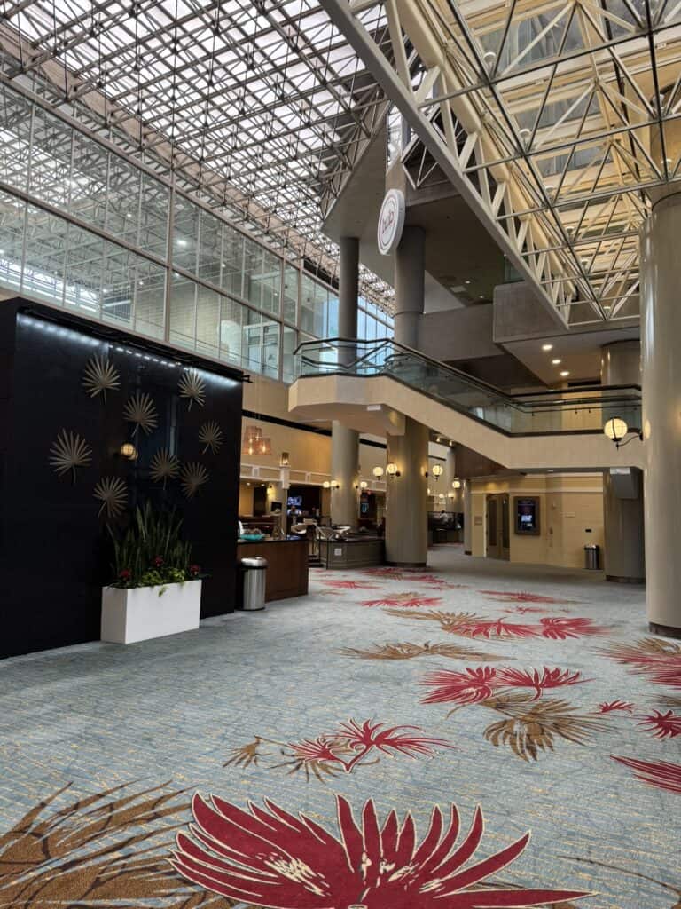 Large open lobby at Marriott Columbia with glass ceiling, staircase, and seating areas.