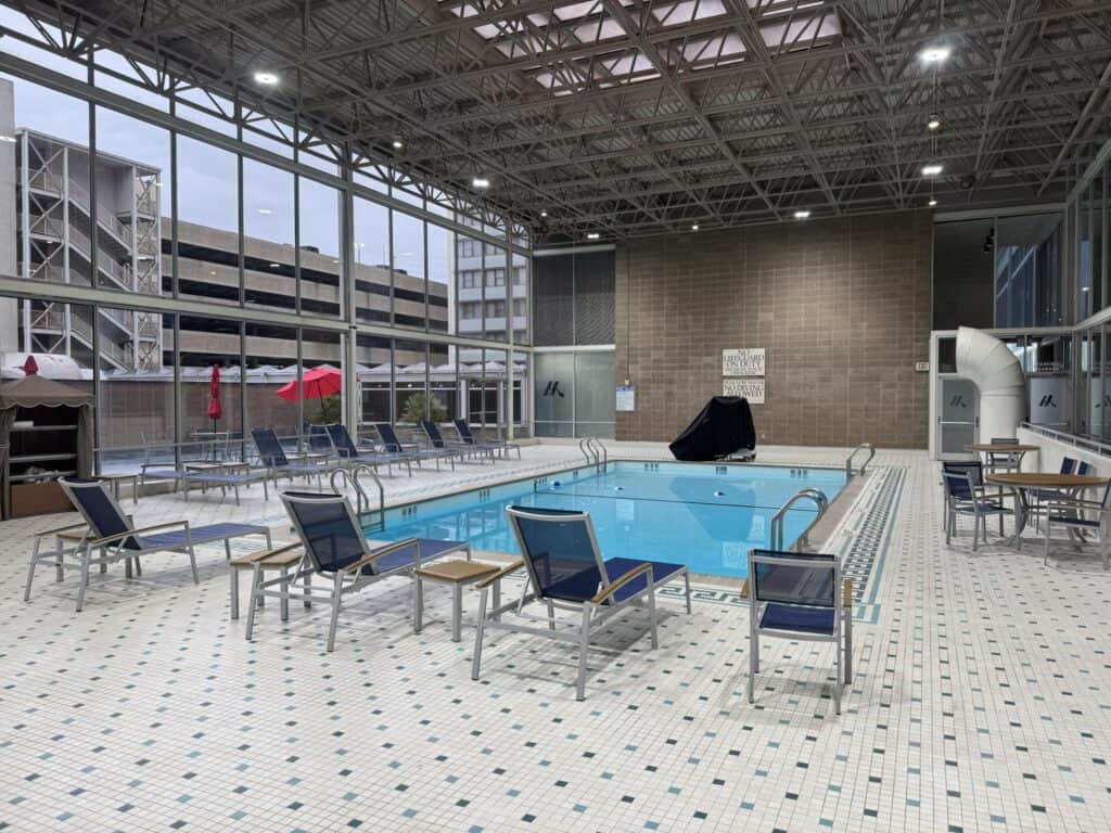 Indoor pool area at Marriott Columbia with lounge chairs and large windows.