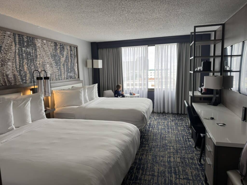 Two queen guest room at Marriott Columbia with kids, including white beds, a desk, and a large window.