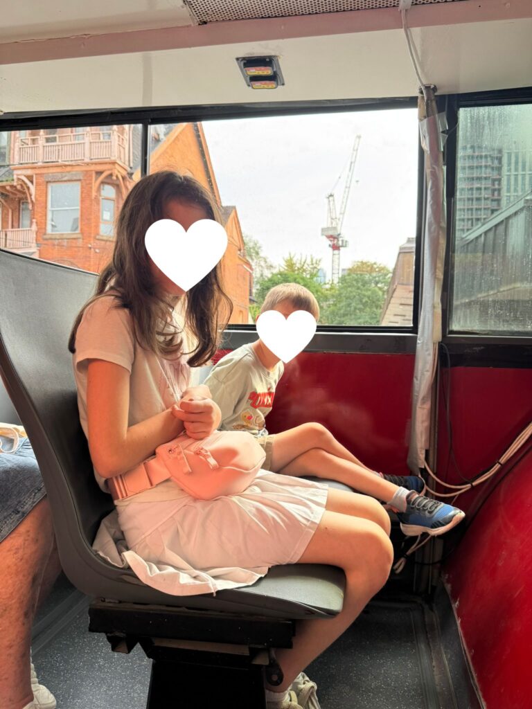 Kids seated on the lower level of a City Sightseeing Toronto double-decker bus
